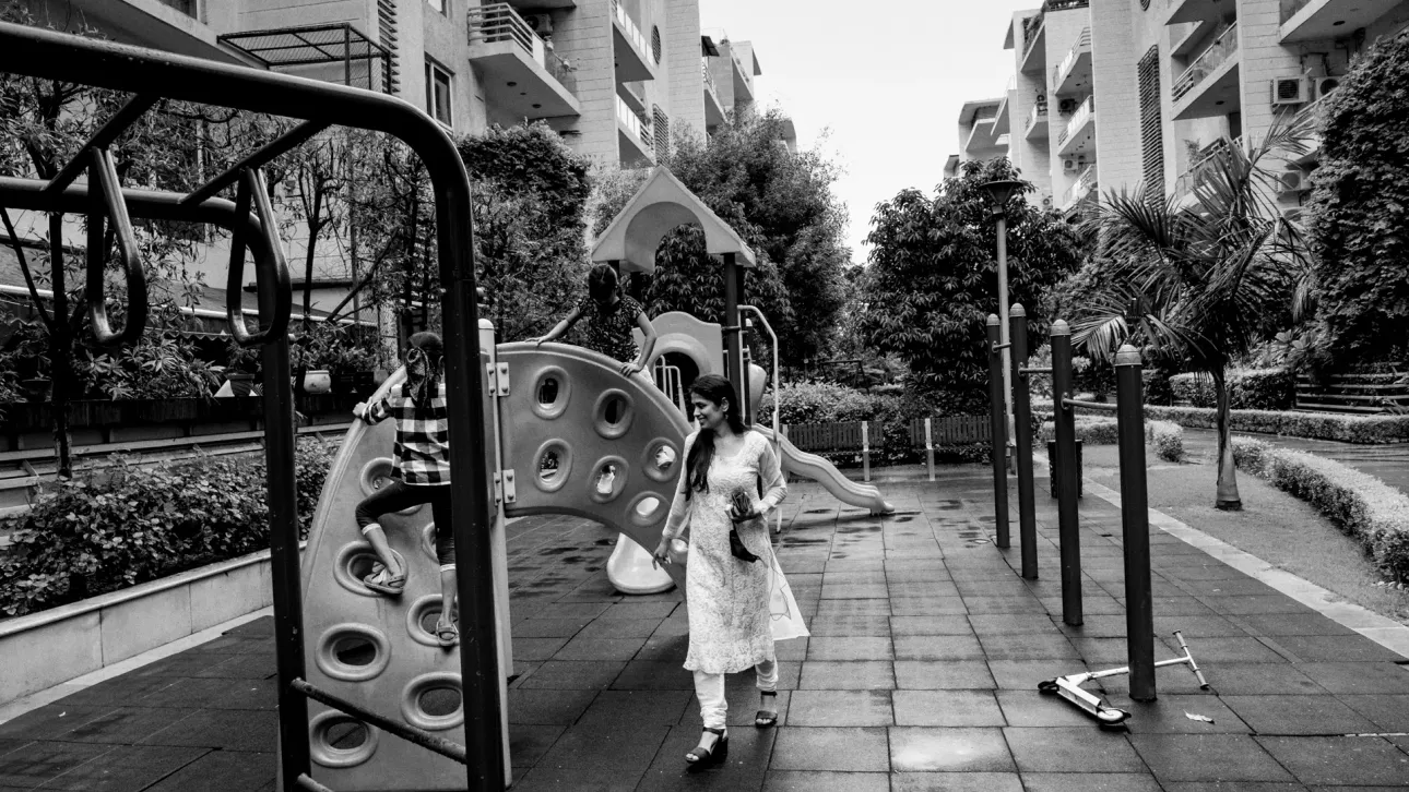 Woman in a playground with her young daughter playing games